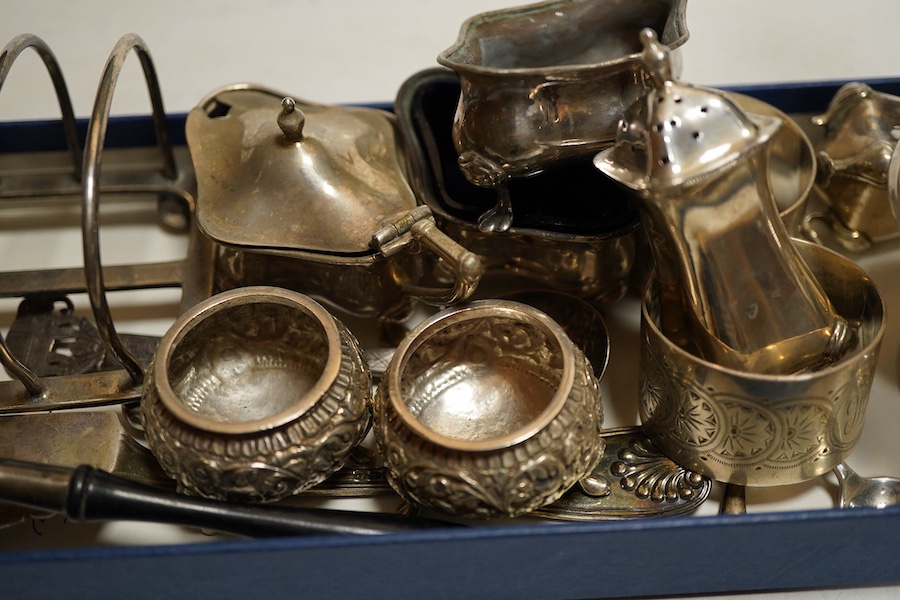 A George V silver sugar caster, Sheffield, 1914, Walker & Hall, together with a four division toast rack, a five peice Edwardian cruet set a/f, a pair of Indian Cutch salts, pair engraved napkin rings, Victorian fiddle,